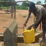 A refugee at a settlement fetching water in Ofua.