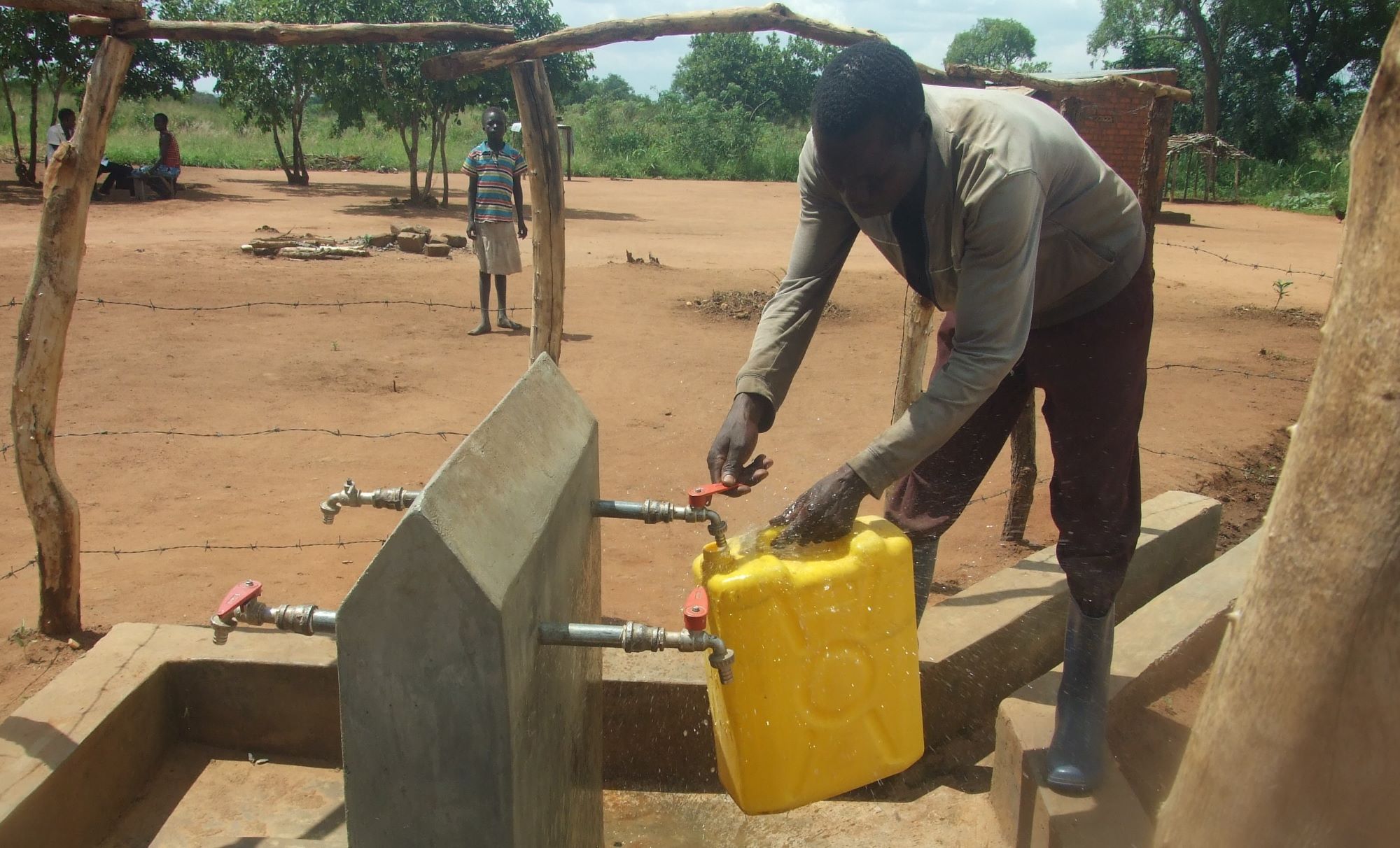 A refugee at a settlement fetching water in Ofua.